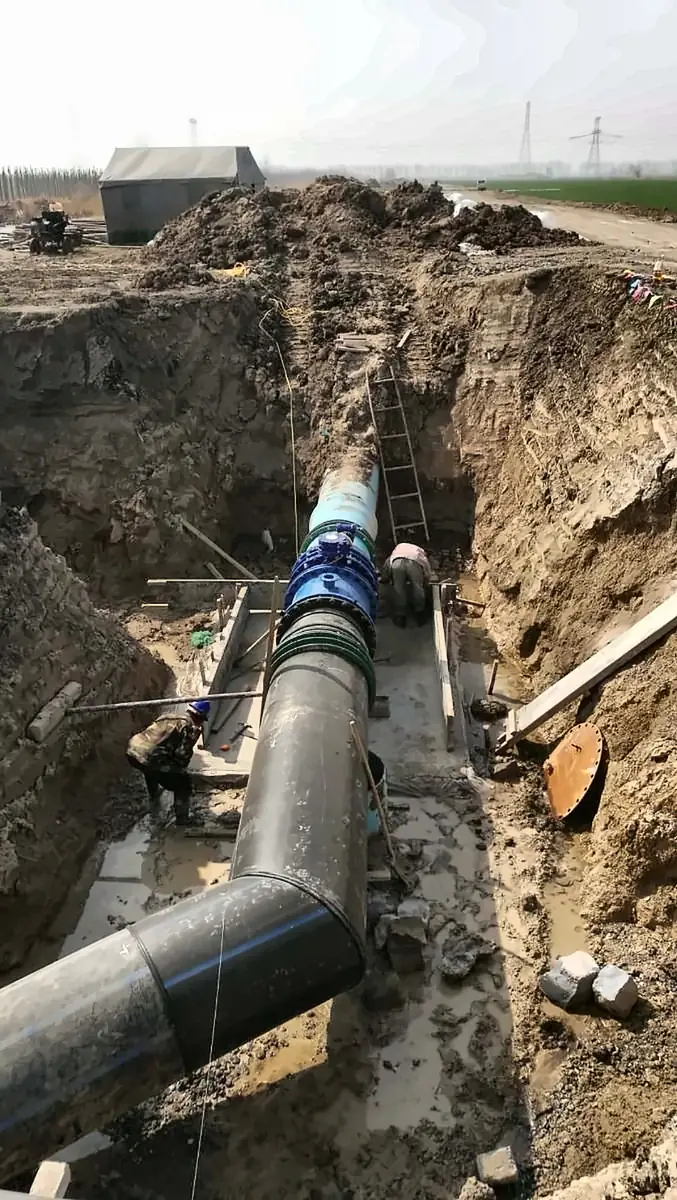 Large-diameter pipeline and valve being installed in a deep trench